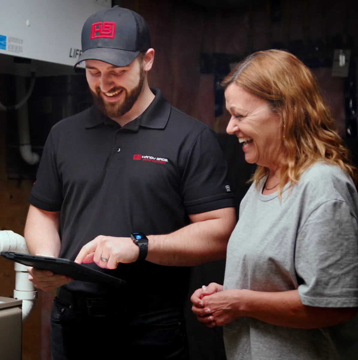 Handy Bros. HVAC technician discussing options with a customer inside their home.