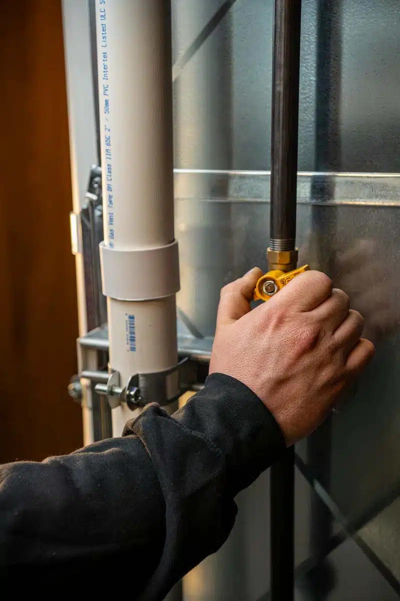 A close-up of a hand adjusting the gas furnace knob, ensuring proper settings for safe and efficient operation.
