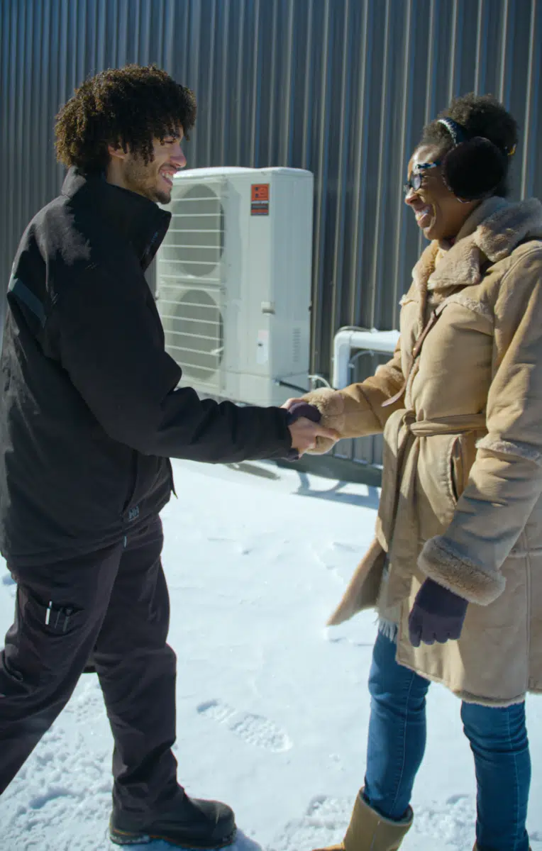 A Handy Bros. technician meeting a customer on a freezing night to repair their furnace, ensuring they stay warm and comfortable.