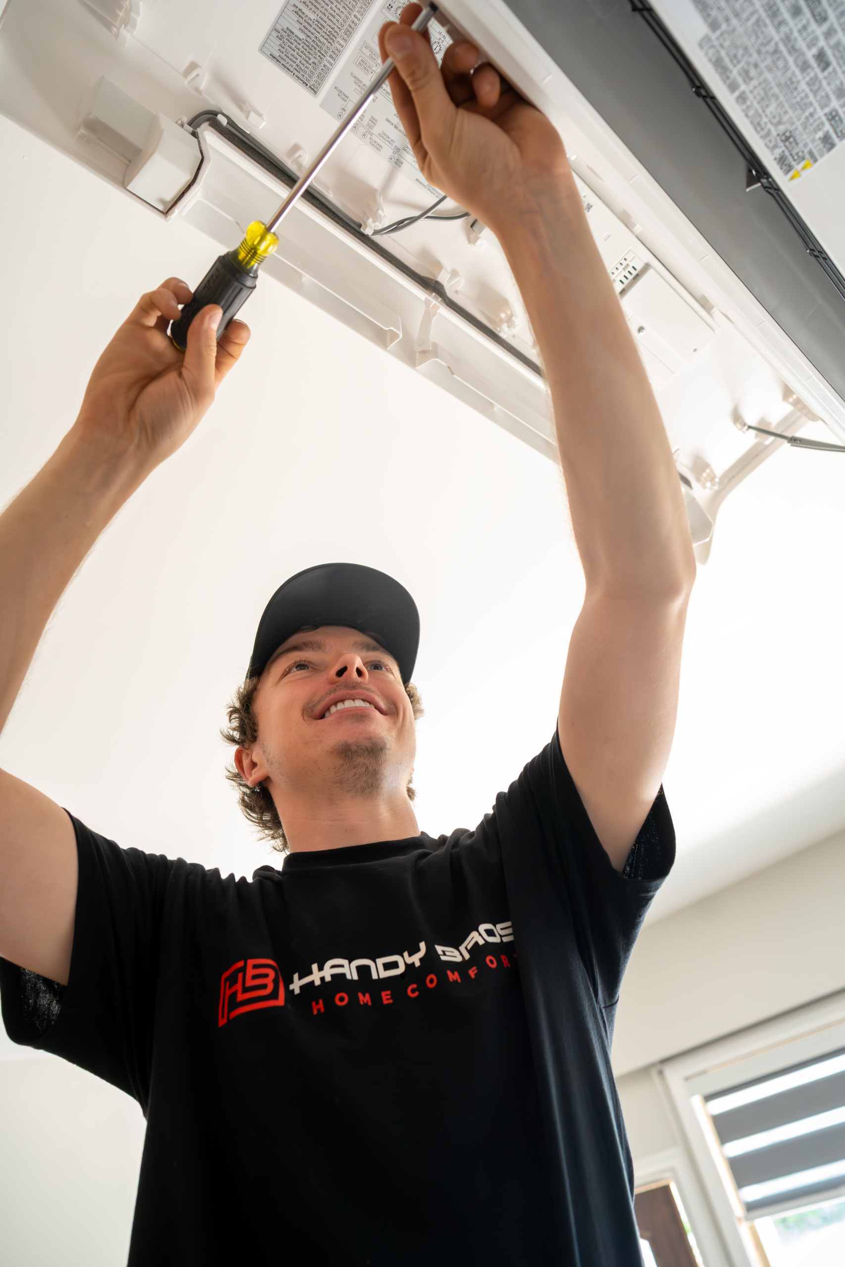 Professional HVAC installer mounting a ductless mini split air conditioner for home comfort.