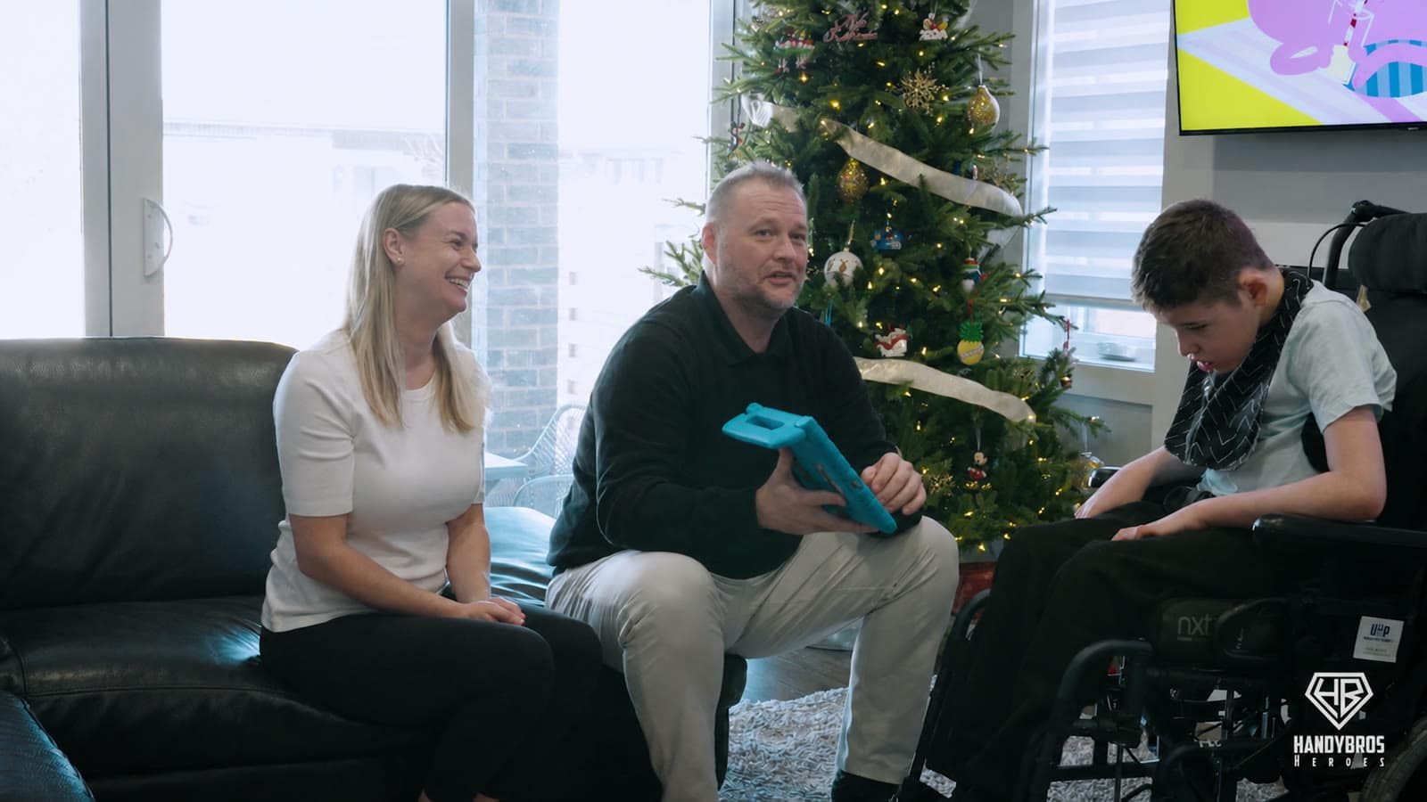 Bentley sits with Amanda and Jeff beside their Christmas tree during the first chapter of Bentley’s Project.