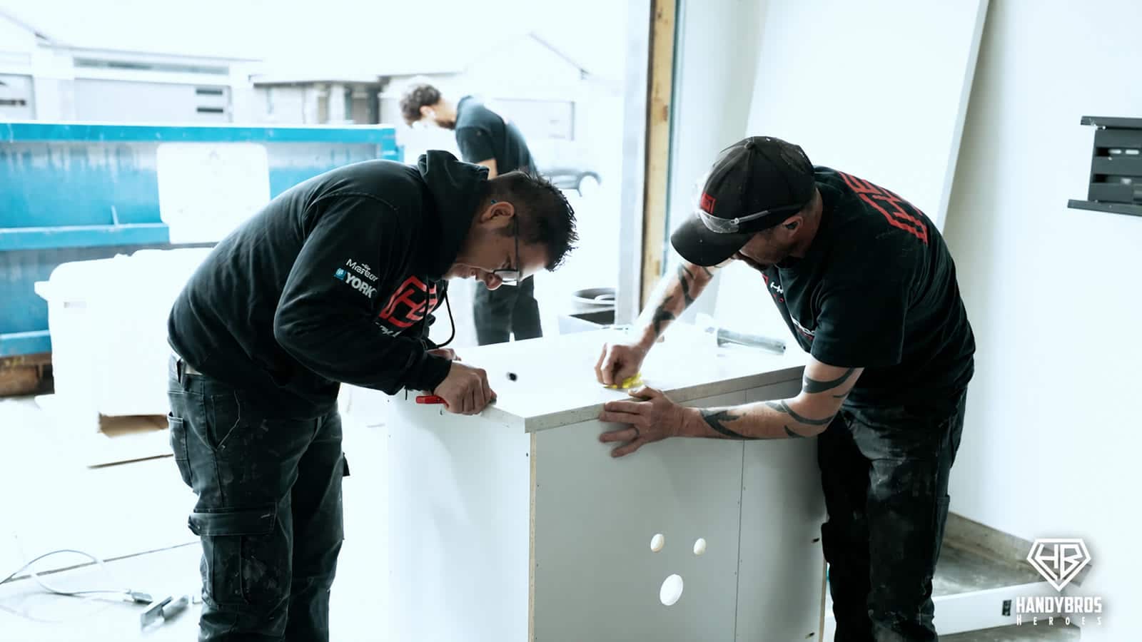 Handy Bros. Heroes tradespeople work together on cabinetry during the compressed accessibility renovation.