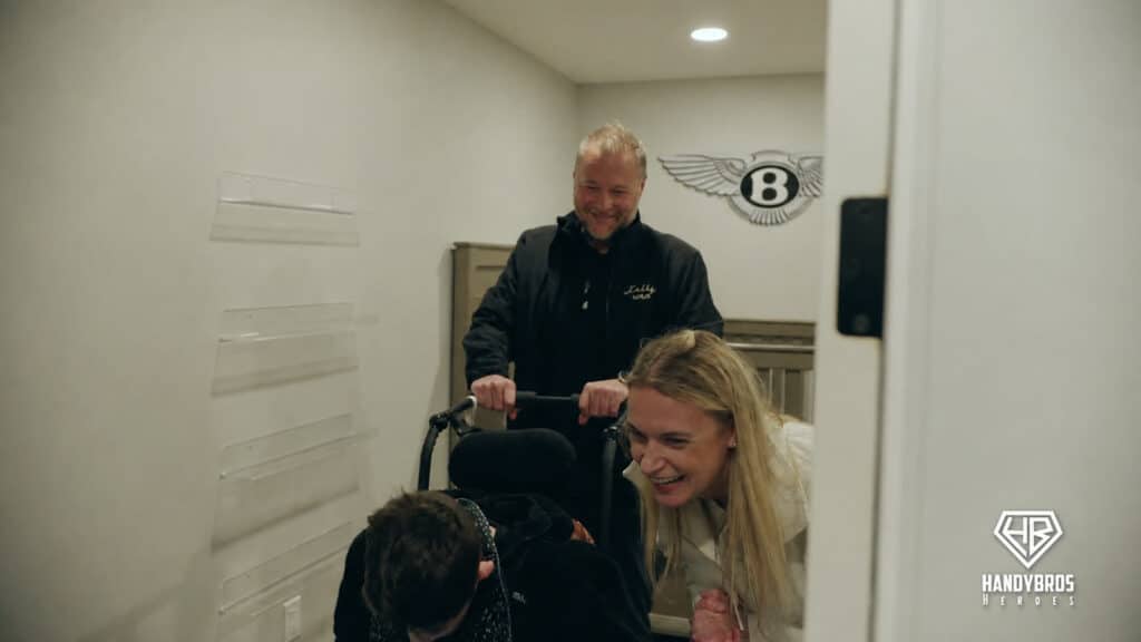 Amanda and Jeff guide Bentley through a widened doorway during the reveal of the renovated home.