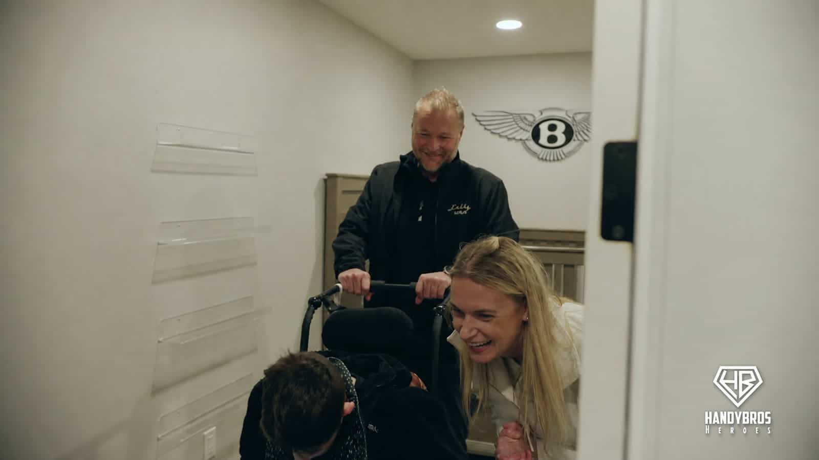 Amanda and Jeff guide Bentley through a widened doorway during the reveal of the renovated home.