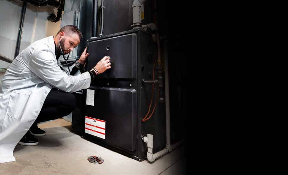 october 2026 furnace tune-up hero - handy bros. home comfort Handy Bros technician servicing a residential furnace